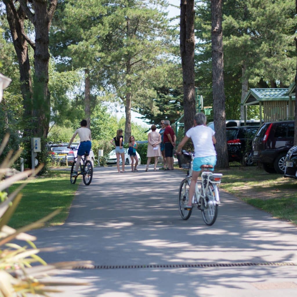 Famille à vélo dans l'enceinte du camping Au Soir d'Été à Mesquer