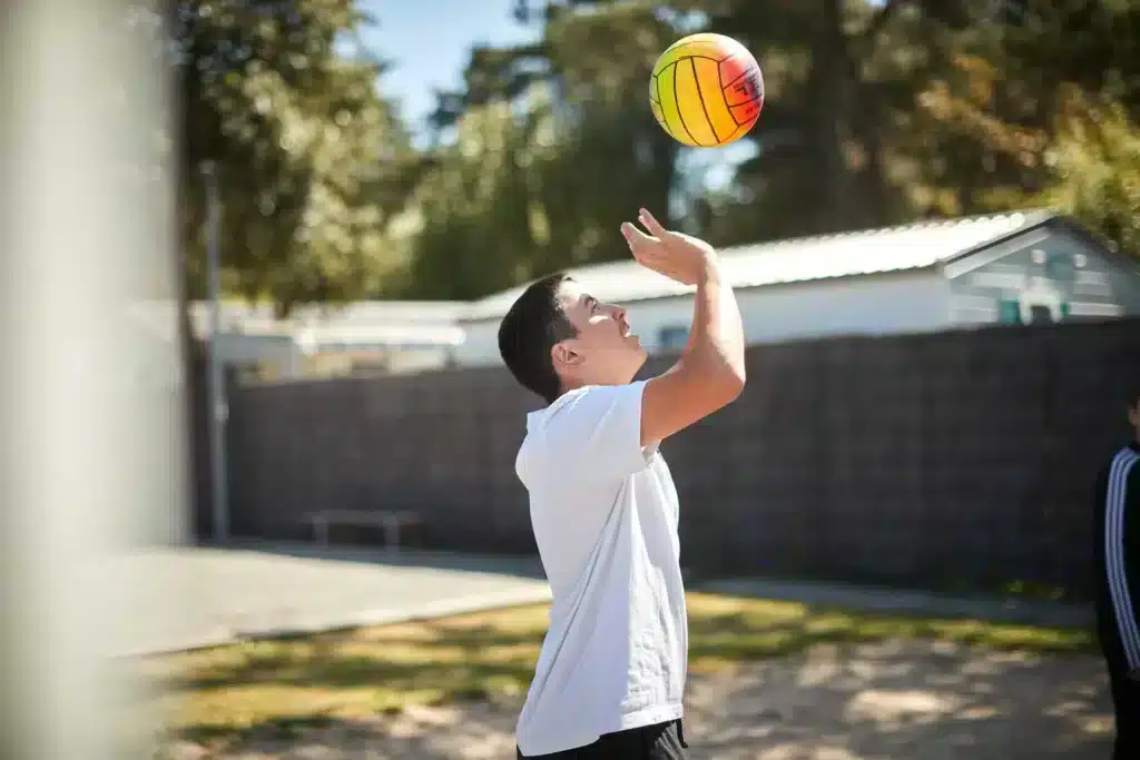 Enfant jouant au volley sur le terrain multisport du camping Au Soir d'Été à Mesquer en Loire-Atlantique