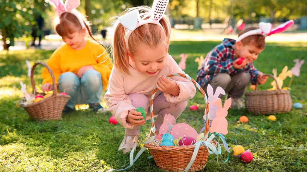 Enfants ramassant les œufs de pâques lors de leurs vacances au camping Au Soir d'Été